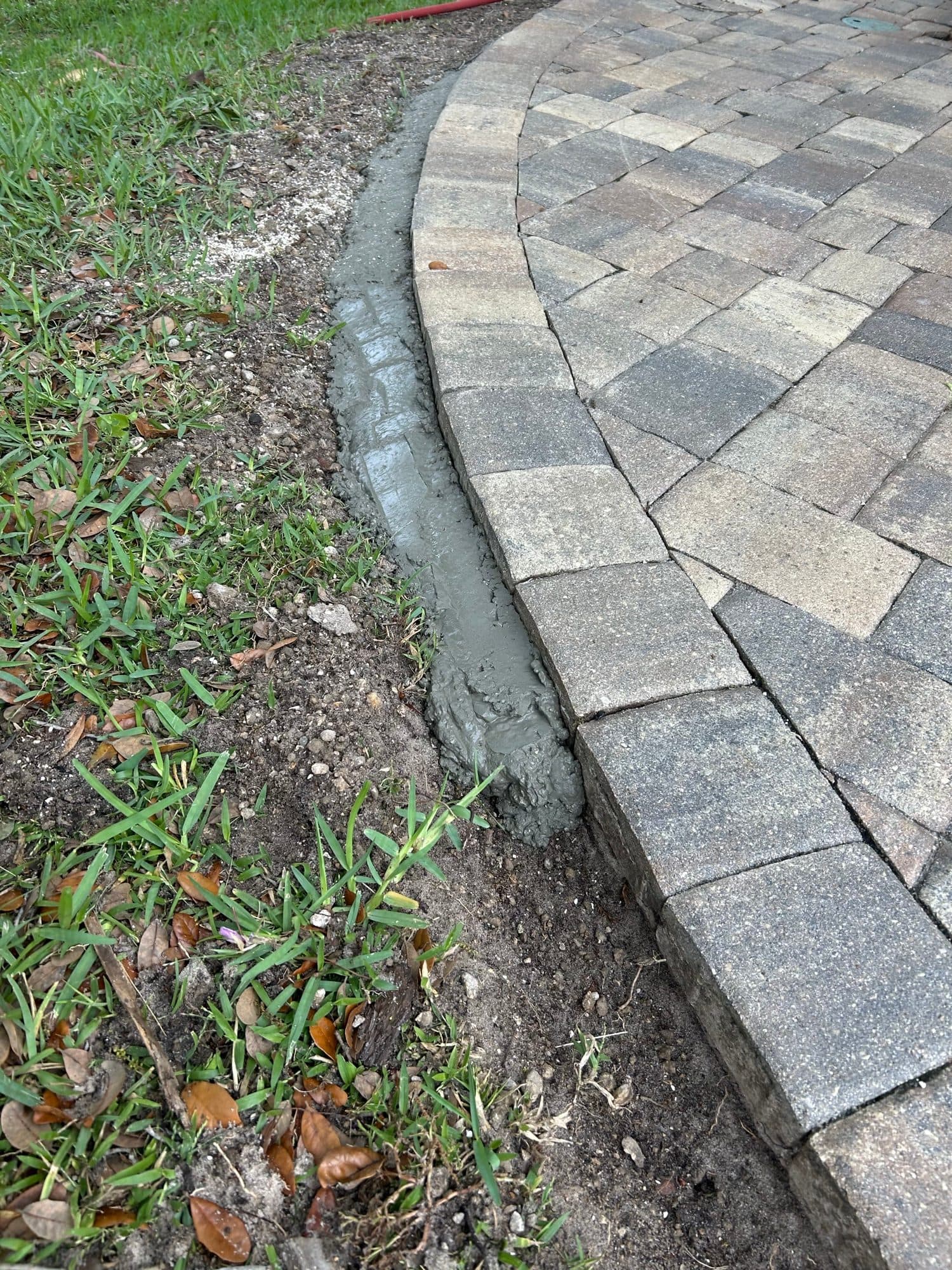 Fresh mortar bedding along paver edge — paver work by Atlantic Exteriors in Brevard County, FL