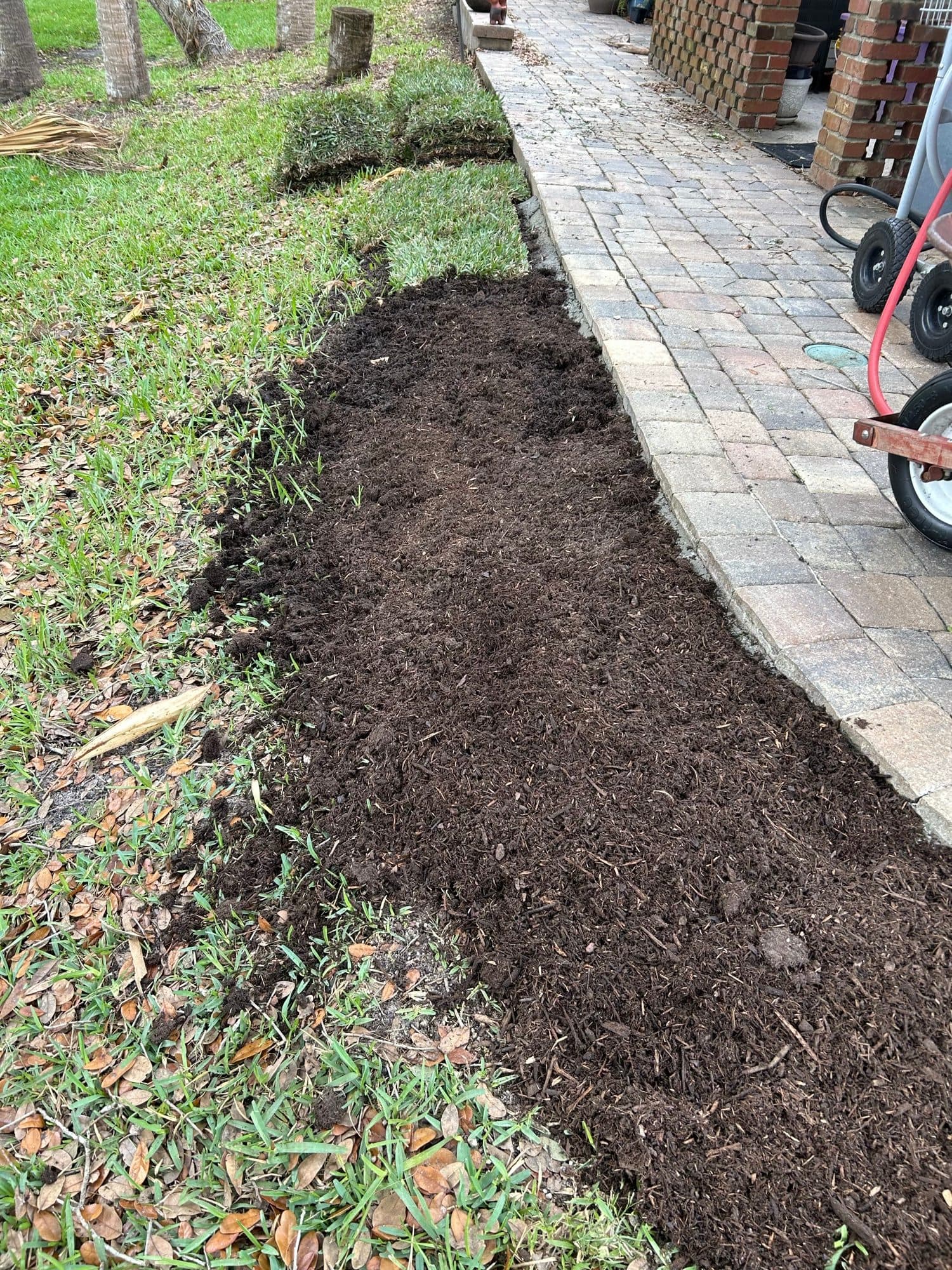 Fresh mulch bed along paver walkway — paver work by Atlantic Exteriors in Brevard County, FL