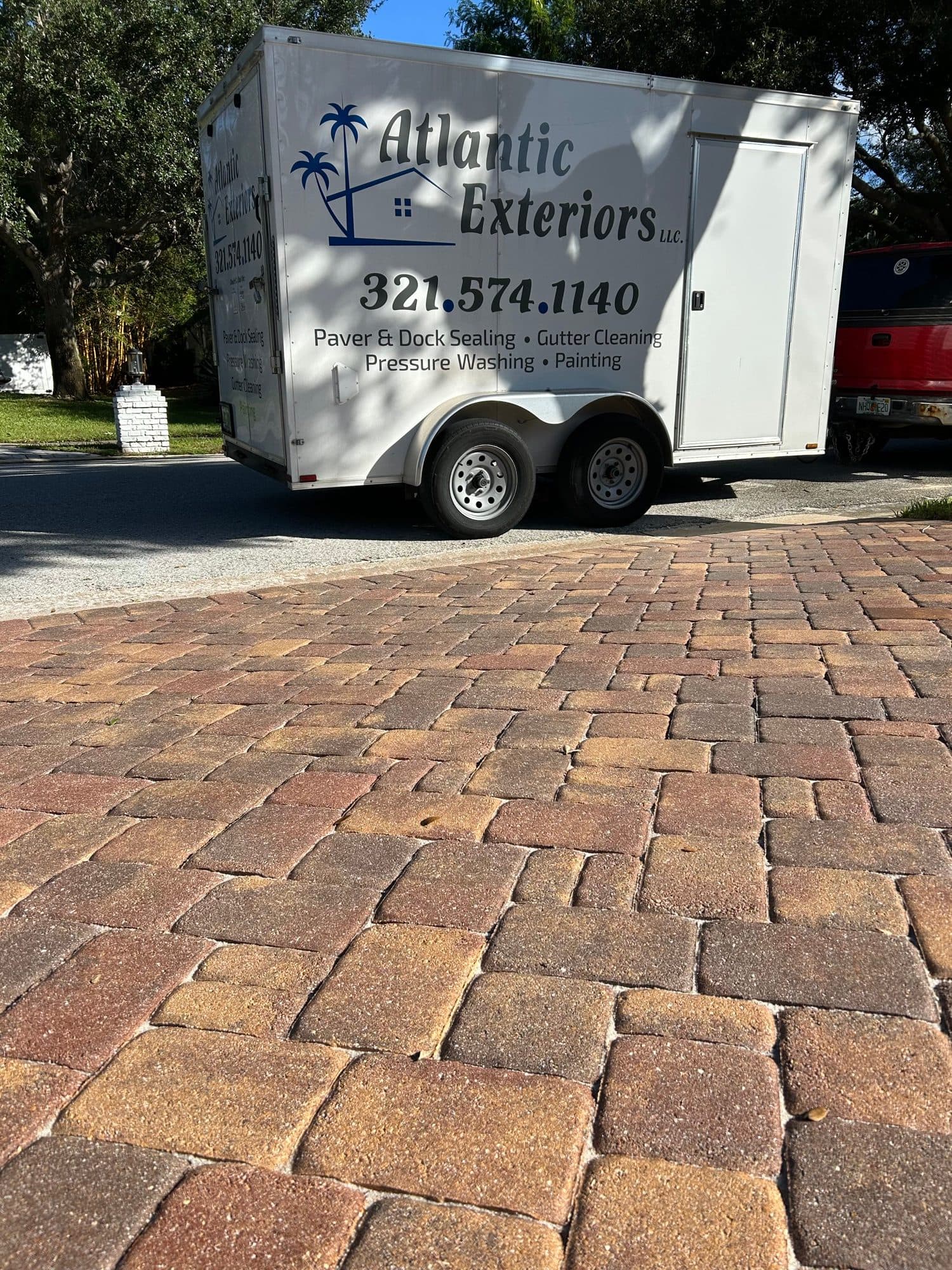 Atlantic Exteriors trailer on sealed driveway — paver work by Atlantic Exteriors in Brevard County, FL