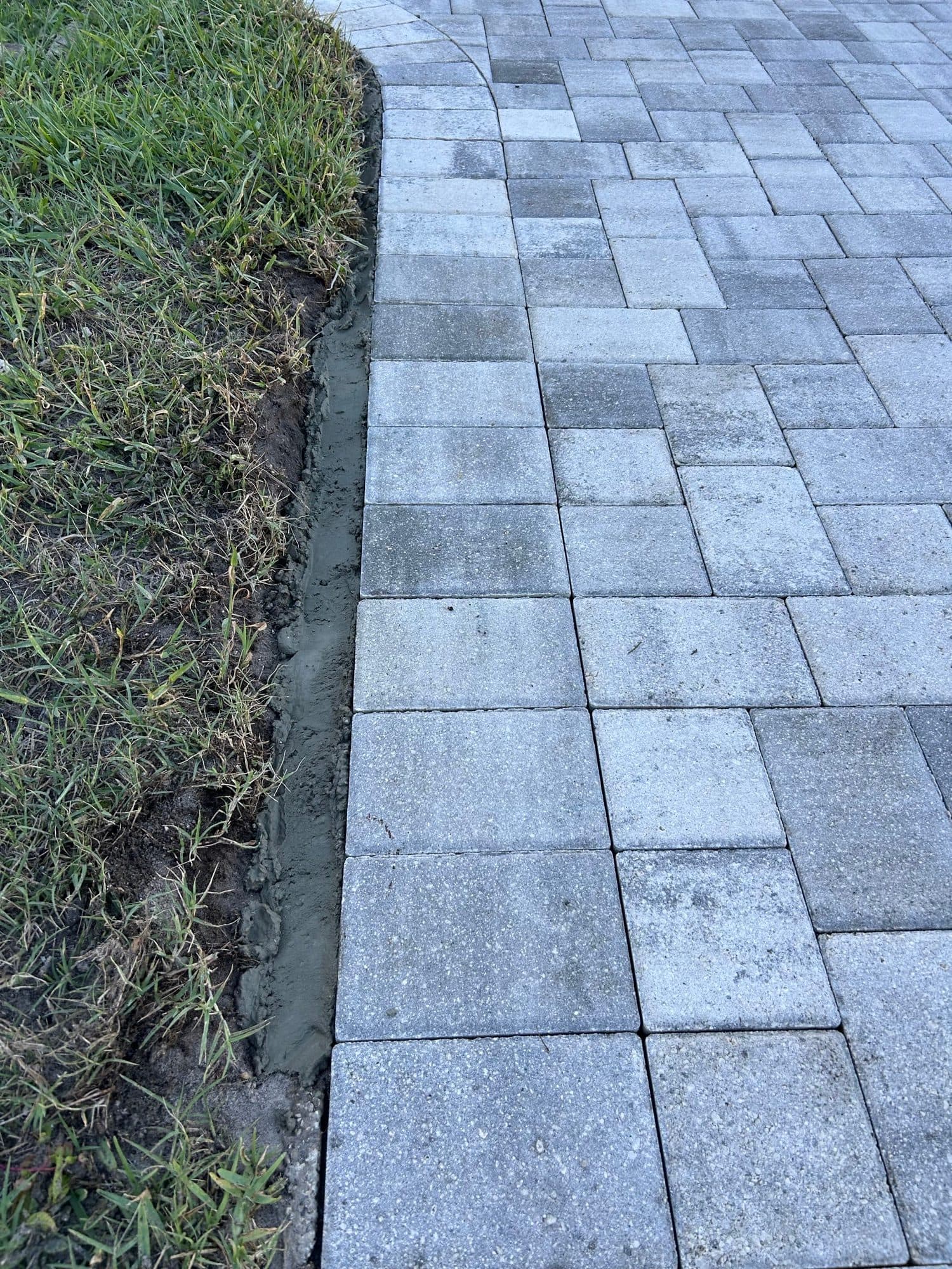 Fresh mortar haunch along driveway edge — paver work by Atlantic Exteriors in Brevard County, FL