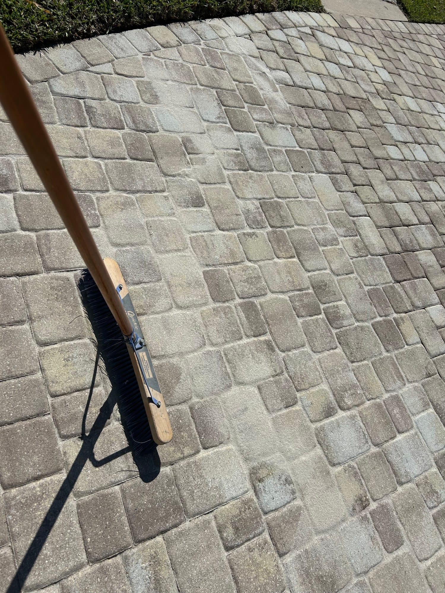 Sweeping fresh joint sand into pavers — paver work by Atlantic Exteriors in Brevard County, FL