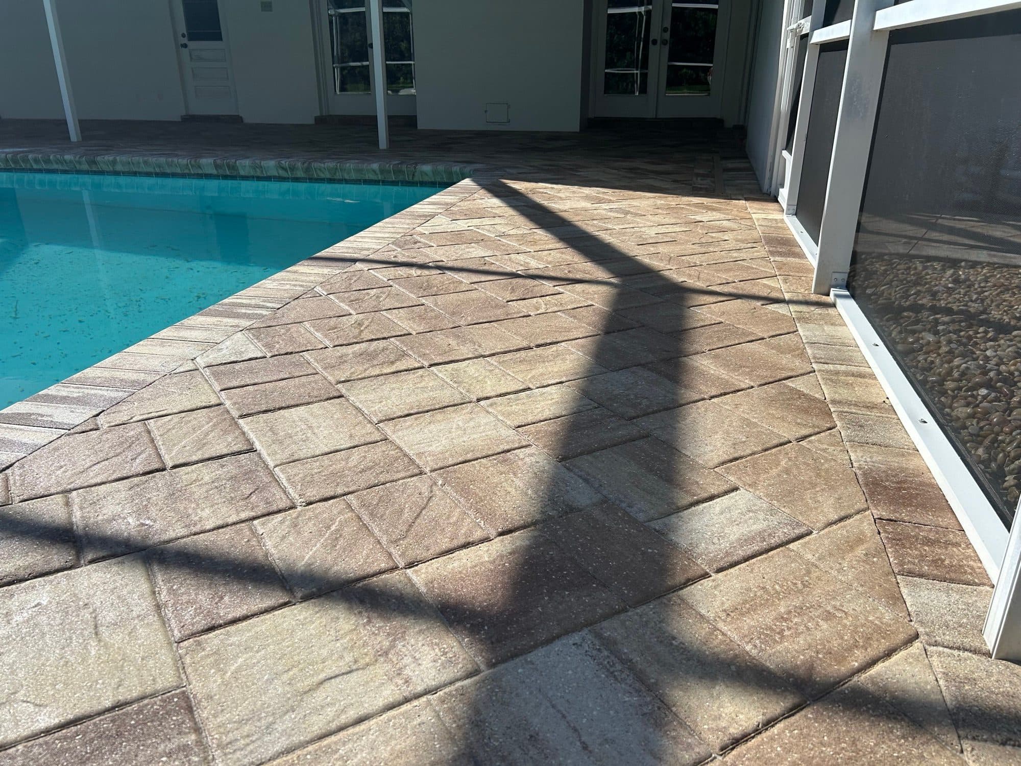 Sealed pool deck in afternoon shade — paver work by Atlantic Exteriors in Brevard County, FL
