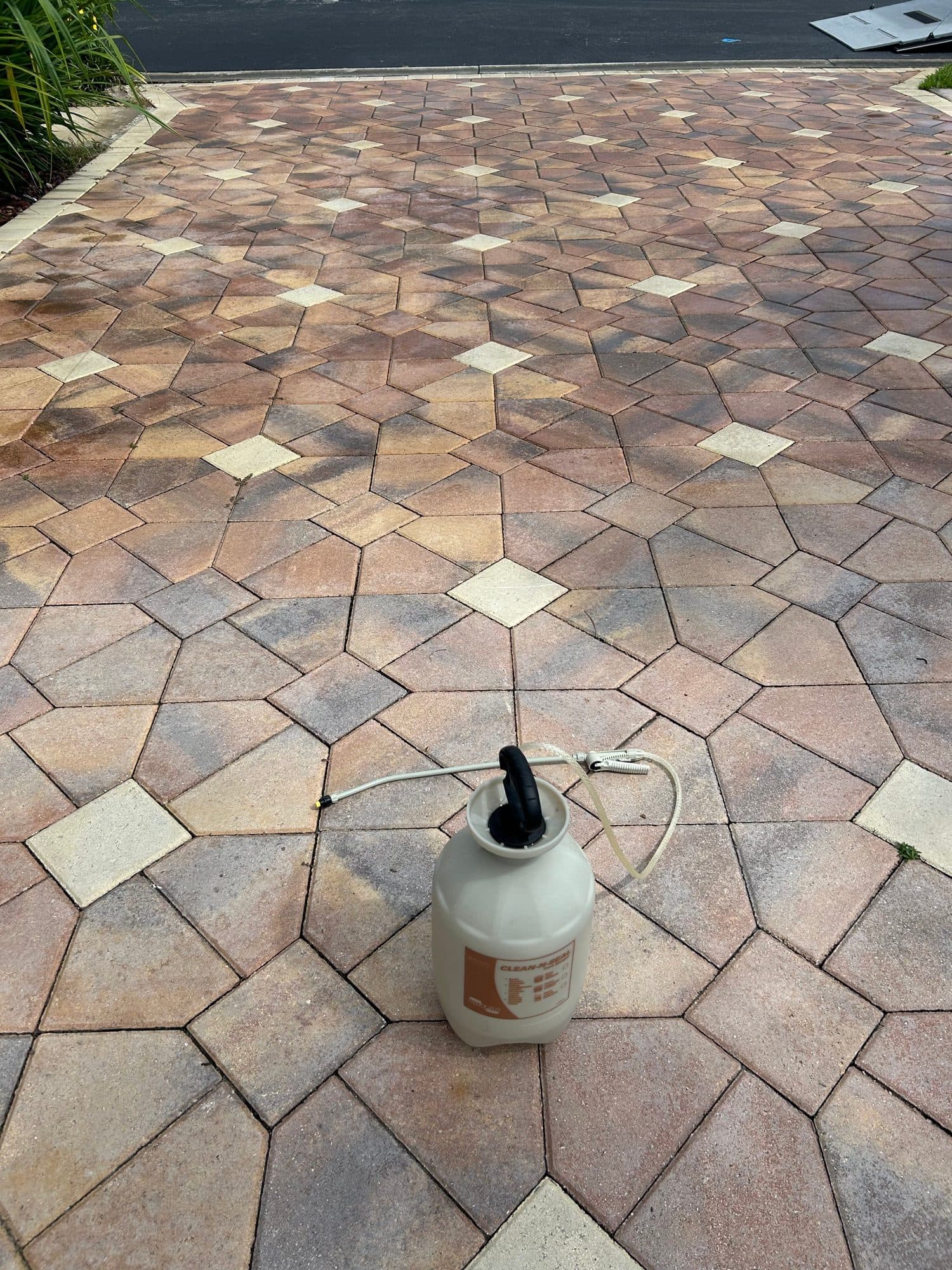 Sealer pump on geometric driveway — paver work by Atlantic Exteriors in Brevard County, FL