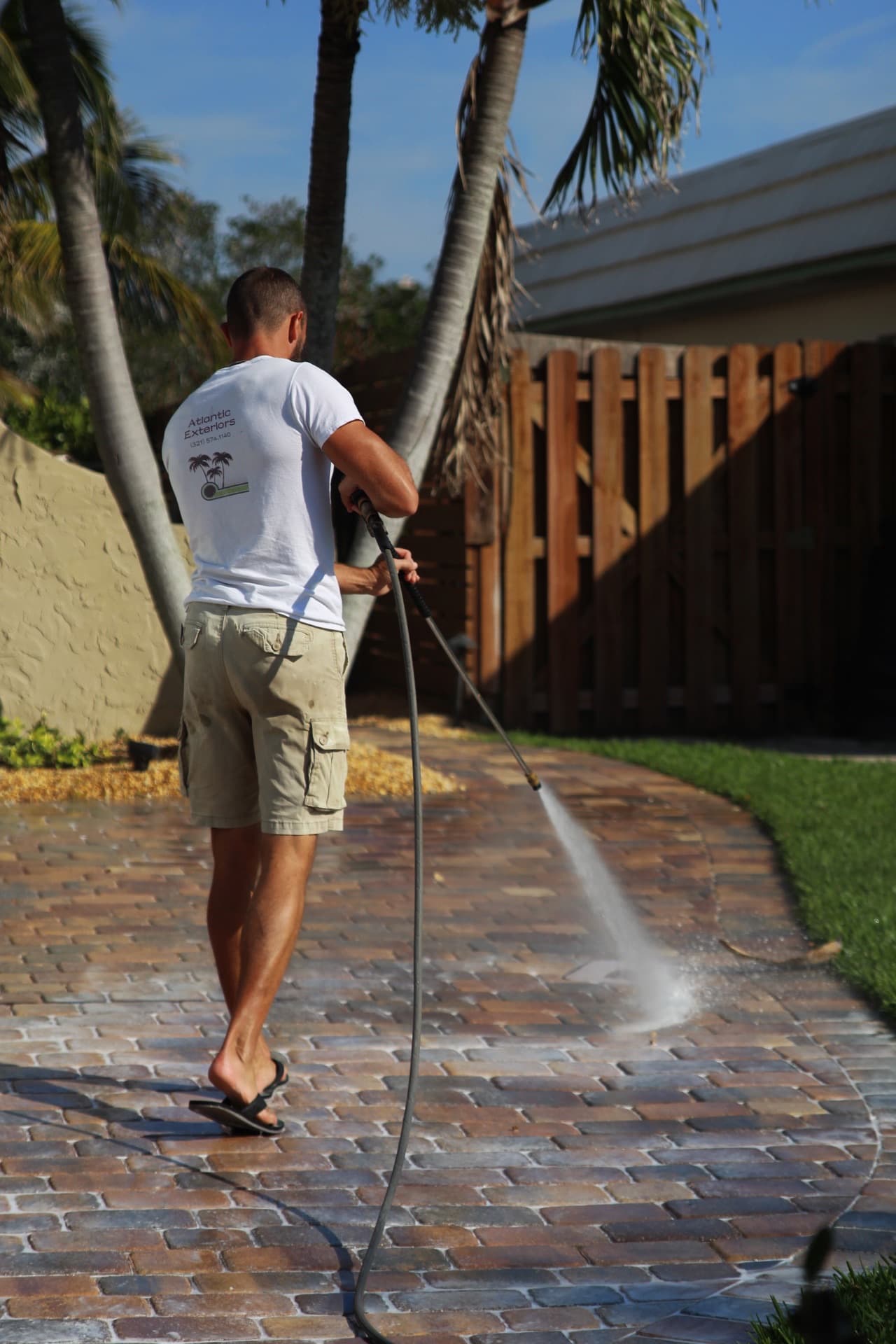Derek pressure-washing a paver walkway — paver work by Atlantic Exteriors in Brevard County, FL