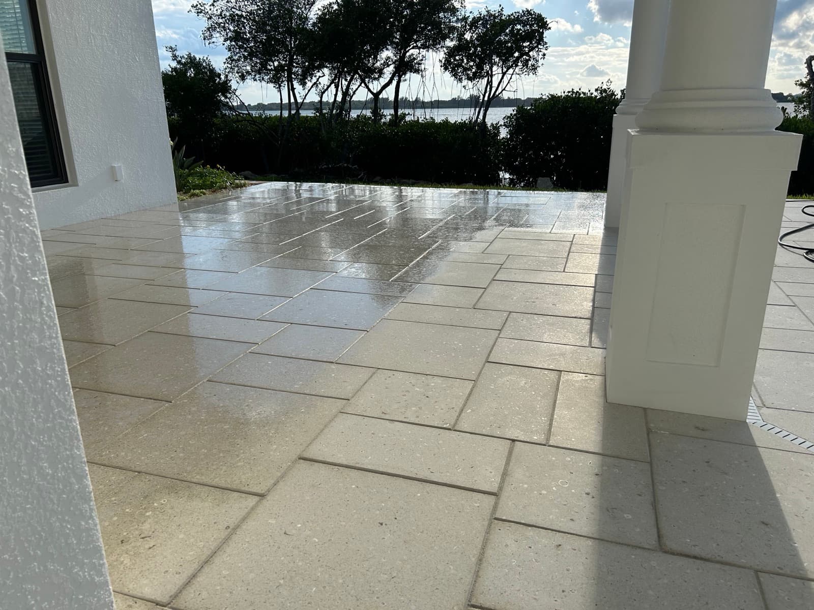 Wet travertine patio overlooking the water — paver work by Atlantic Exteriors in Brevard County, FL